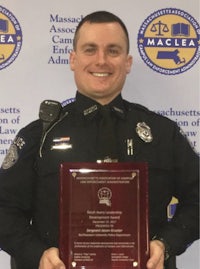 a police officer holding an award in front of a background